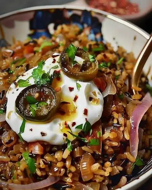 Plat de Mujadara avec lentilles et riz garni d'oignons frits
