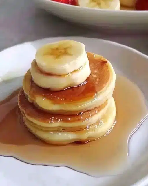 Pancakes japonais moelleux et légers servis avec du sirop d'érable.