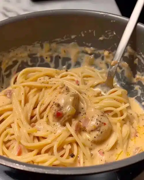 Plat de pâtes au poulet crémeux servi avec des herbes fraîches