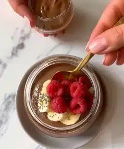 Pudding de chia au chocolat garnie de fruits et éclats de chocolat.