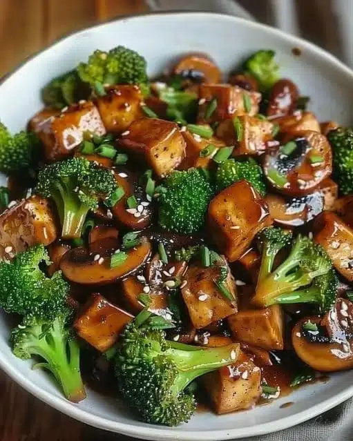 Sauté de champignons et de tofu dans une poêle, plat végétarien prêt à servir.