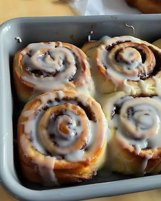 Roules à la cannelle moelleux avec glaçage crémeux sur une assiette