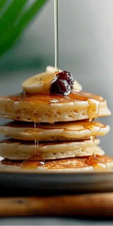 Pancakes moelleux empilés avec des fruits frais et du sirop d'érable