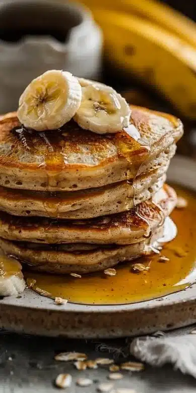 Pancakes banane avoine dorés servis avec des fruits frais